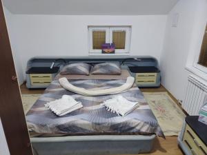 a bedroom with a bed with a blanket and two pillows at Apartmani Mladenović in Kijevo
