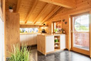 una cocina en una casa de madera con ventana en Starmacher Hof, en Itter