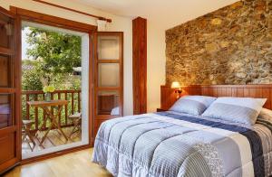 1 dormitorio con cama y pared de piedra en Cal Francès, en All