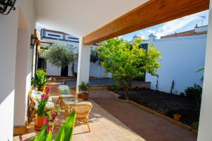 un patio con sillas y plantas en una casa en El Molino del Huertezuelo, en La Palma del Condado