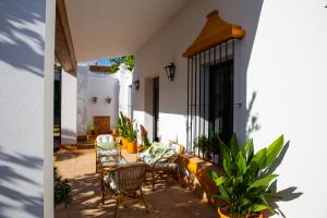 un patio de una casa con sillas y mesas en El Molino del Huertezuelo, en La Palma del Condado