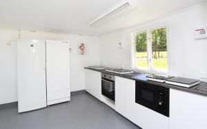 a white kitchen with a counter and a refrigerator at Urshult Glamping in Urshult