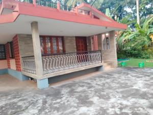 a house with a bench in front of it at Reunion Villa in Udupi