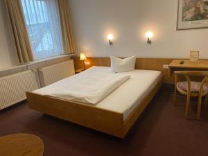 A bed or beds in a room at Hotel Rosengarten Tuttlingen