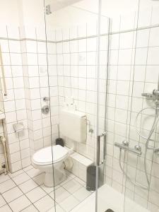 a white bathroom with a toilet and a shower at Ferienwohnung Calabria Nr 2 in Mülheim an der Ruhr +12 photos