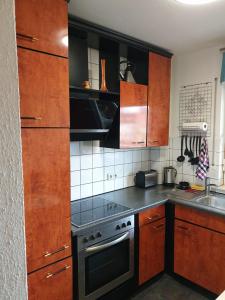 a kitchen with wooden cabinets and a stove top oven at Ferienwohnung Calabria Nr 2 in Mülheim an der Ruhr