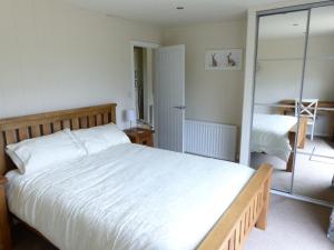 Un dormitorio con una gran cama blanca y un espejo. en Shropshire Lodges - Romantic Luxury Hot Tub Breaks, en Bridgnorth 28 fotos más