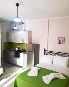 a bedroom with a green bed with towels on it at Green Studio Nidri in Nydri
