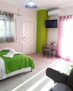 a bedroom with green walls and a bed and a table at Green Studio Nidri in Nydri