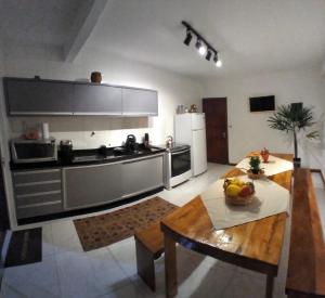 a large kitchen with a table in a room at Pousada Maria Eduarda in Guarda do Embaú