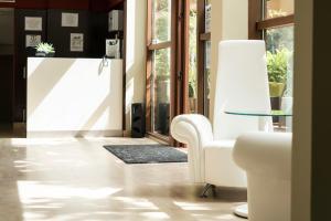 a living room with a white chair and a glass table at Hotel Piramide 2 in Portonovo