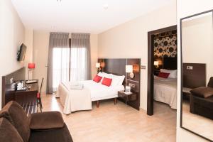 une chambre d'hôtel avec un lit et un salon dans l'établissement Hotel Piramide 2, à Portonovo