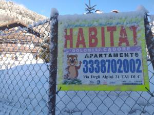 un cartello su una rete con la neve sopra di Habitat Dolomiti-Cadore a Pieve di Cadore