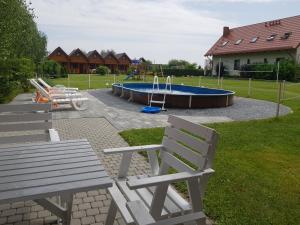 park z 2 ławkami i basenem w obiekcie Domki Morskie Opowieści w mieście Mikoszewo