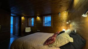 a bedroom with a bed in a room with windows at mini duplex dans chalet in Saint-François-Longchamp