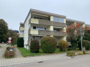 un edificio con arbustos delante de él en una calle en BodenSEE Apartment Wasserburg Sonnhaldenstraße, en Wasserburg