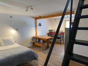 a bedroom with a bed, chair, table and a lamp at French Andes Apart Hostel in Pucón