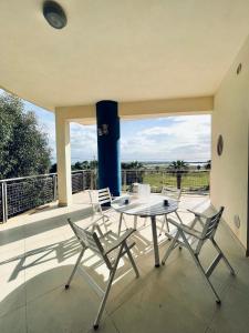 a patio with a table and chairs on a balcony at Casa Serra in Porto Palo