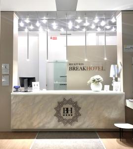 a lobby with a reception counter with a breach hotel sign at Break Hotel in Ospedaletto Lodigiano