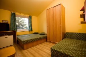 a small room with two beds and a window at Penzion Adriana in Patince