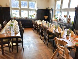a dining room with tables and chairs and windows at Albhotel Malakoff - House of Nature in Wiesensteig
