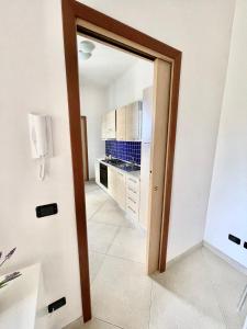 a door leading to a kitchen with white cabinets at Casa Serra in Porto Palo