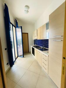 a kitchen with wooden cabinets and a large window at Casa Serra in Porto Palo