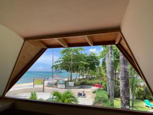 um quarto com uma grande janela com vista para a praia em guest house MY WAY em Las Terrenas