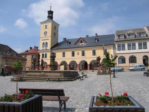 a building with a clock tower in a courtyard at Hotel Na Staré poště in Jilemnice