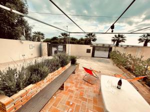 a patio with a table and chairs and plants at Casa Serra in Porto Palo