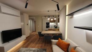 sala de estar y cocina con mesa y sofá en Napfény Resort Exclusive, en Balatonlelle