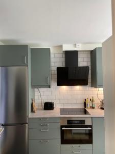 a kitchen with a stainless steel refrigerator and cabinets at Åreskutans Mountain Lodge i Huså Lägenhet 03 in Huså