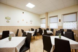 a dining room with tables and chairs and windows at Apartmány Hawaii in Patince