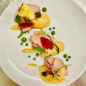 a white plate with food on a table at Hotel Diana in Valdobbiadene