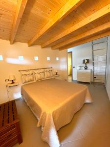 a bedroom with a large bed with a wooden ceiling at Casa Serra in Porto Palo