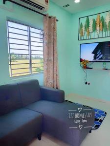 a living room with a blue couch and a window at Izz Homestay Sawah Padi Sungai Besar ! in Kampong Parit Ten