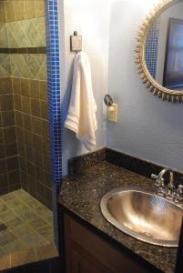 uma casa de banho com um lavatório, um chuveiro e um espelho. em Sierra Trails Retreat em Mariposa