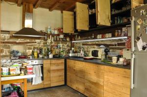 a kitchen with wooden cabinets and a stone wall at Adventure Camp Emen in Emen