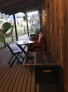 a porch with a table and chairs on a wooden deck at Container Encantada in Garopaba