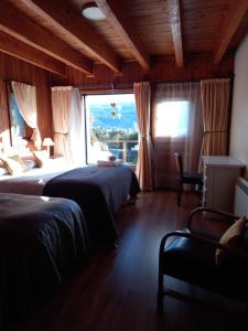 una camera con due letti e una grande finestra di Hostería Encanto del Lolog a San Martín de los Andes