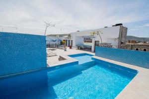 a swimming pool with blue tiles on a building at Suites de La Parra in Oaxaca City