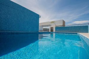a large blue swimming pool next to a building at Suites de La Parra in Oaxaca City