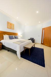 a bedroom with a large bed with a blue rug at Suites de La Parra in Oaxaca City