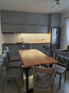 a kitchen with a wooden table and chairs and a refrigerator at Świerkowa Chata in Bałtów +10 photos