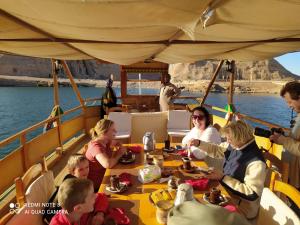 people sitting at a table in a boat at Eskaleh Eco-Lodge in Abu Simbel