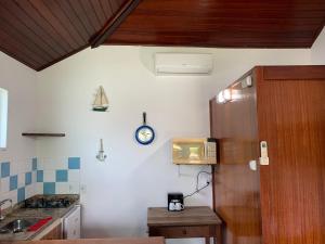 a kitchen with a counter and a clock on the wall at Kitchenette near the Beach/including Breakfast in Búzios