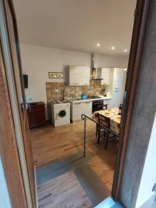 a kitchen with white appliances and a wooden floor at CASA LA FALEGNAMERIA in Bivigliano