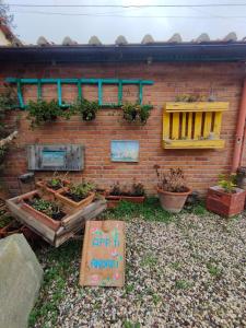 a brick wall with plants and a sign in front of it at CASA LA FALEGNAMERIA in Bivigliano
