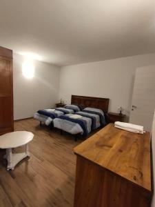 a room with two beds and a table in it at CASA LA FALEGNAMERIA in Bivigliano