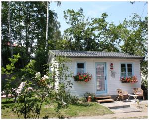 mały biały domek z kwiatami na oknie w obiekcie Willa Ludwinia w mieście Gdynia